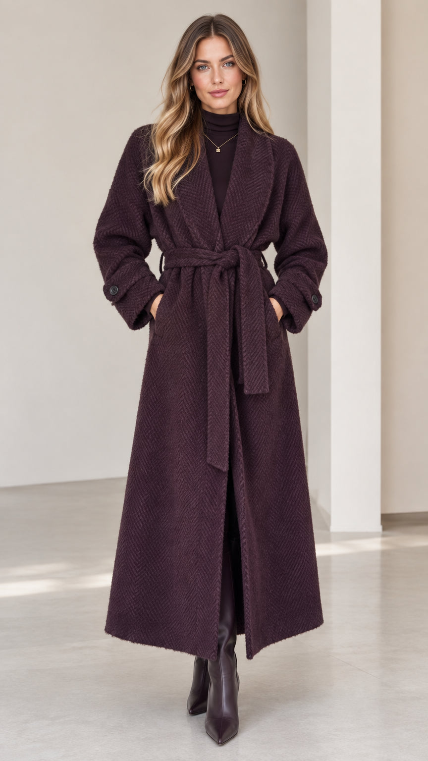 Front view of woman wearing deep plum herringbone maxi wrap coat with belt