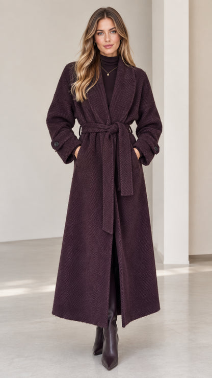 Front view of woman wearing deep plum herringbone maxi wrap coat with belt