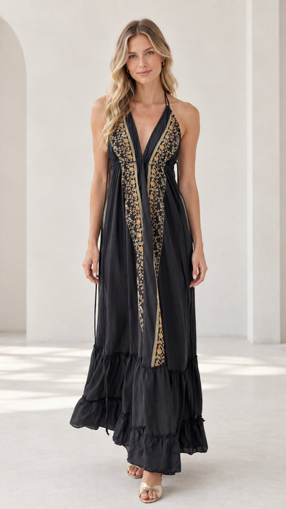 Front view of model wearing black embroidered halter backless tiered maxi dress