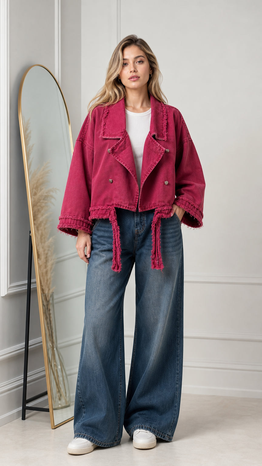Front view of model wearing magenta cropped denim moto jacket with frayed edges and wide-leg jeans