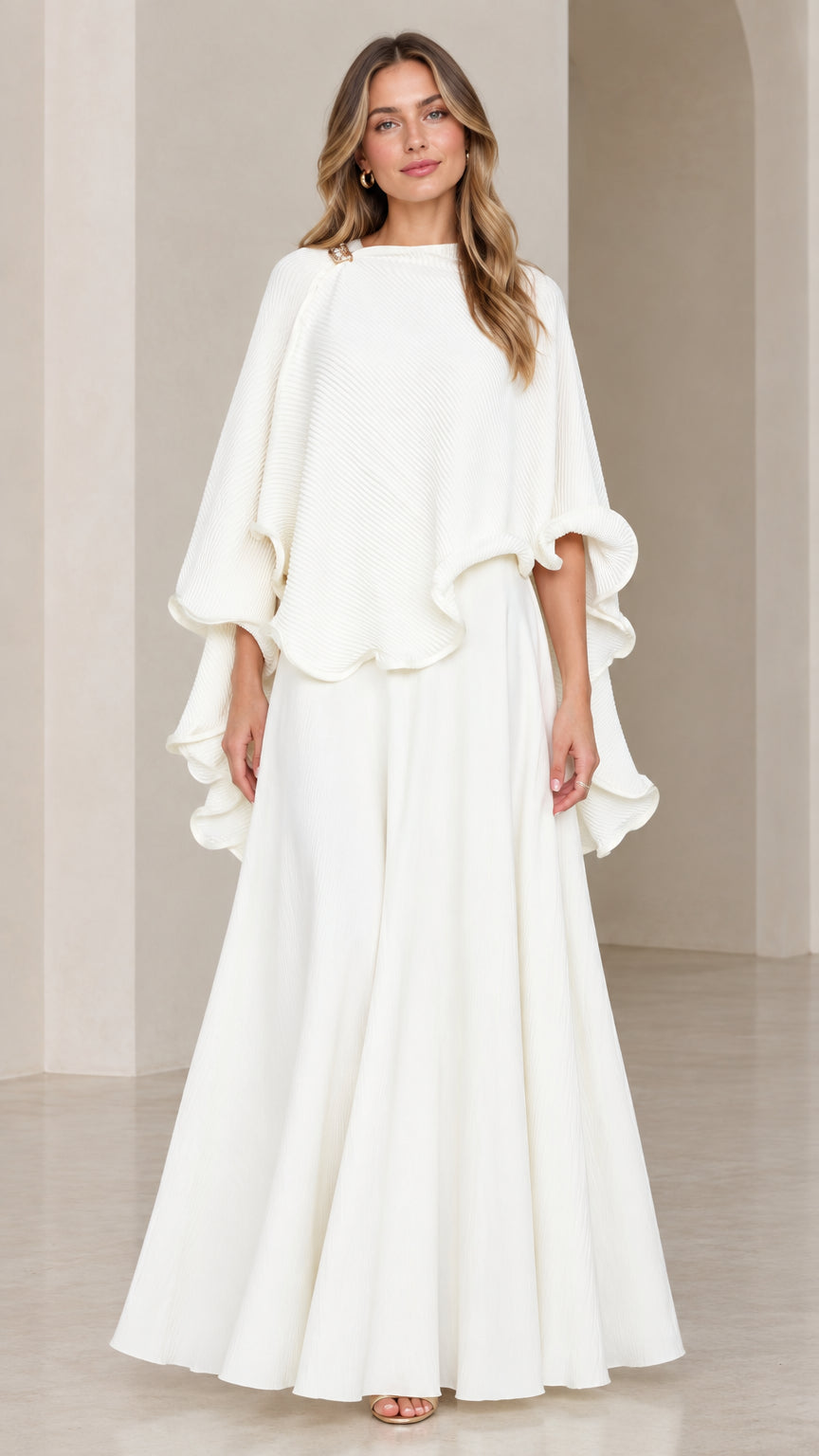 Front view of model wearing white asymmetrical capelet top and maxi skirt set