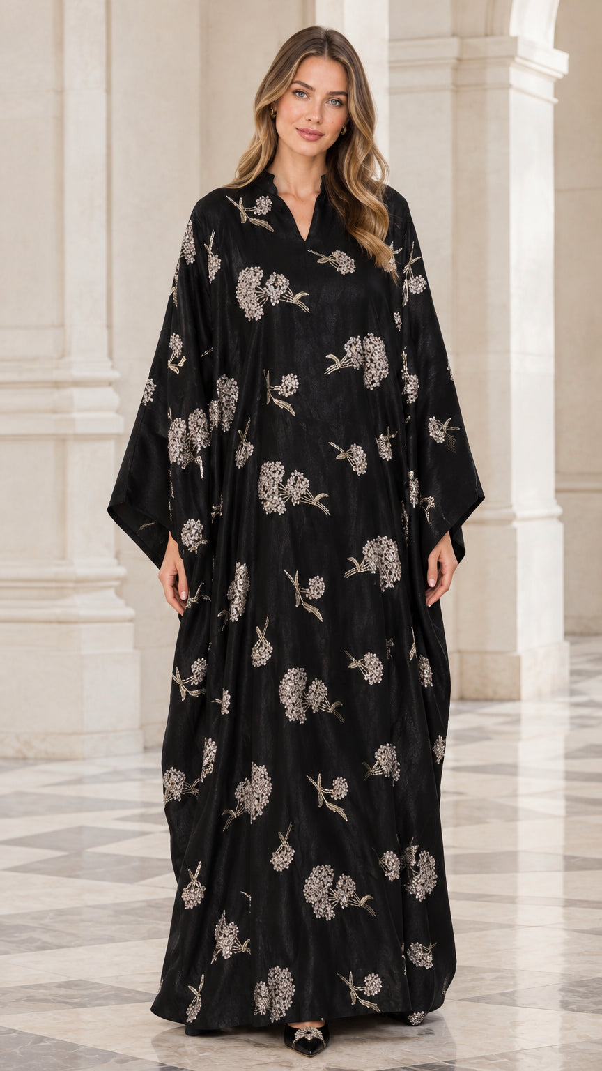 Front view of woman wearing black floral embroidered kaftan maxi dress with wide sleeves