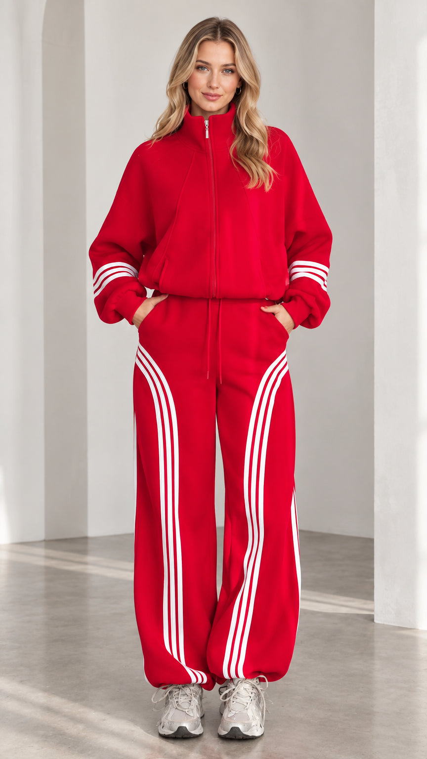 Front view of woman wearing red zip-up jacket and wide-leg striped track pants set