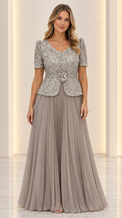 Full front view of slate grey sequin peplum evening gown with pleated skirt