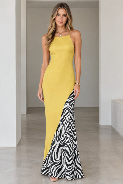 Front view of model wearing a yellow backless maxi dress with zebra print side panel insert
