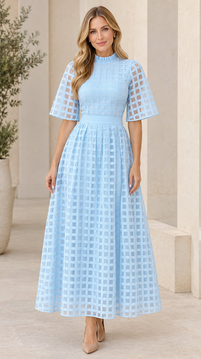 Front full-length view of woman wearing light blue mock neck sheer grid overlay maxi dress