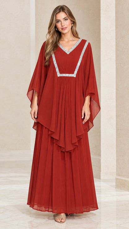 Front view of woman wearing rust red layered kaftan maxi dress with silver embroidered V-neck