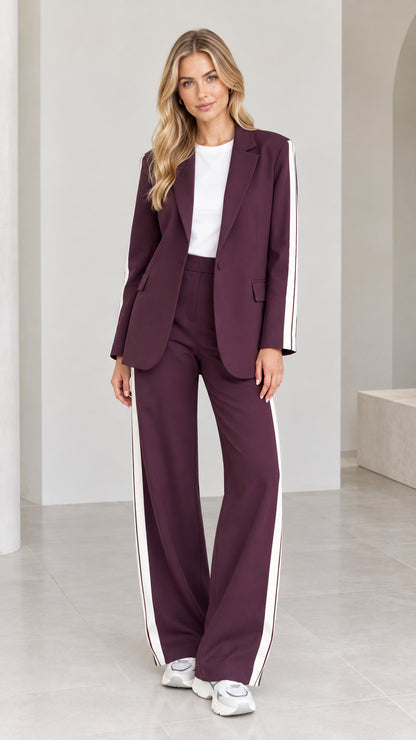 Full front view of model wearing burgundy 2-piece blazer and wide-leg pants suit with white side stripes