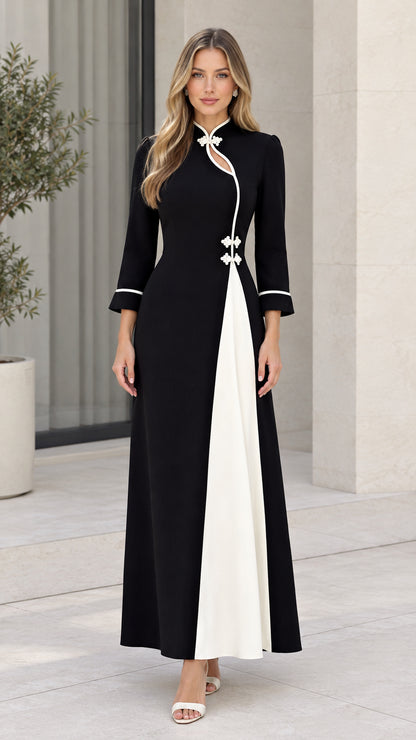 Front view of woman wearing modern black maxi dress with white contrast panel and floral frog buttons