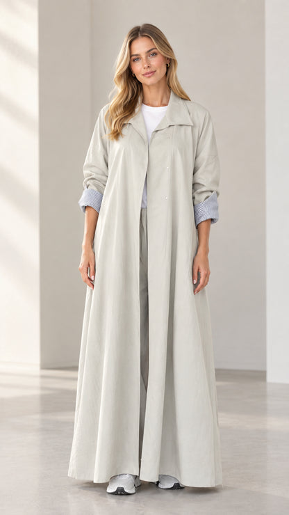 Front full-length view of woman wearing light grey maxi duster coat with matching trousers