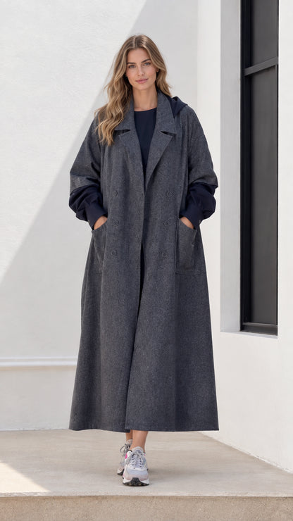Front view of woman wearing charcoal grey hooded maxi trench coat with sneakers