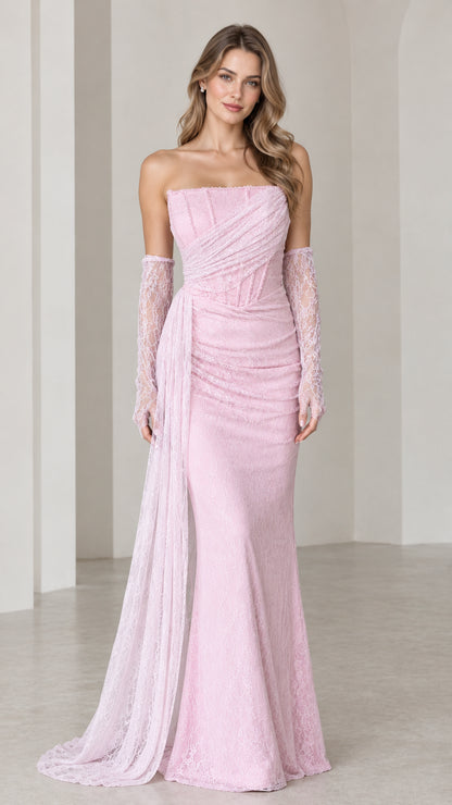 Front full view of woman wearing strapless pink lace evening gown with draped side sash and lace gloves