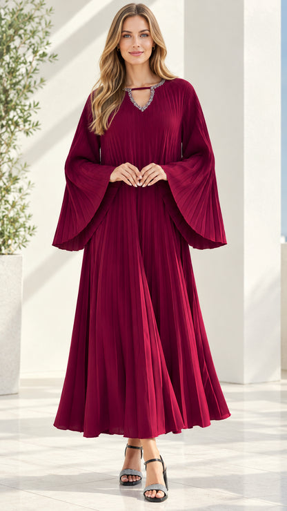 Front view of model wearing burgundy pleated maxi dress with embellished neckline and bell sleeves