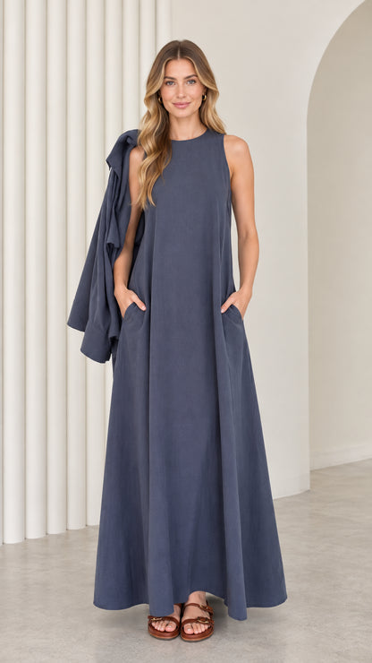 Front full-length view of model wearing the sleeveless slate blue maxi dress with side pockets