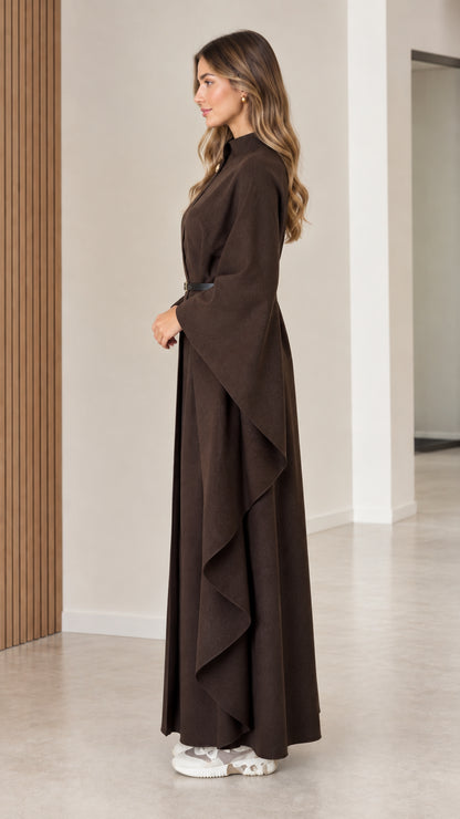 Side profile of brown floor-length draped cape coat with belt