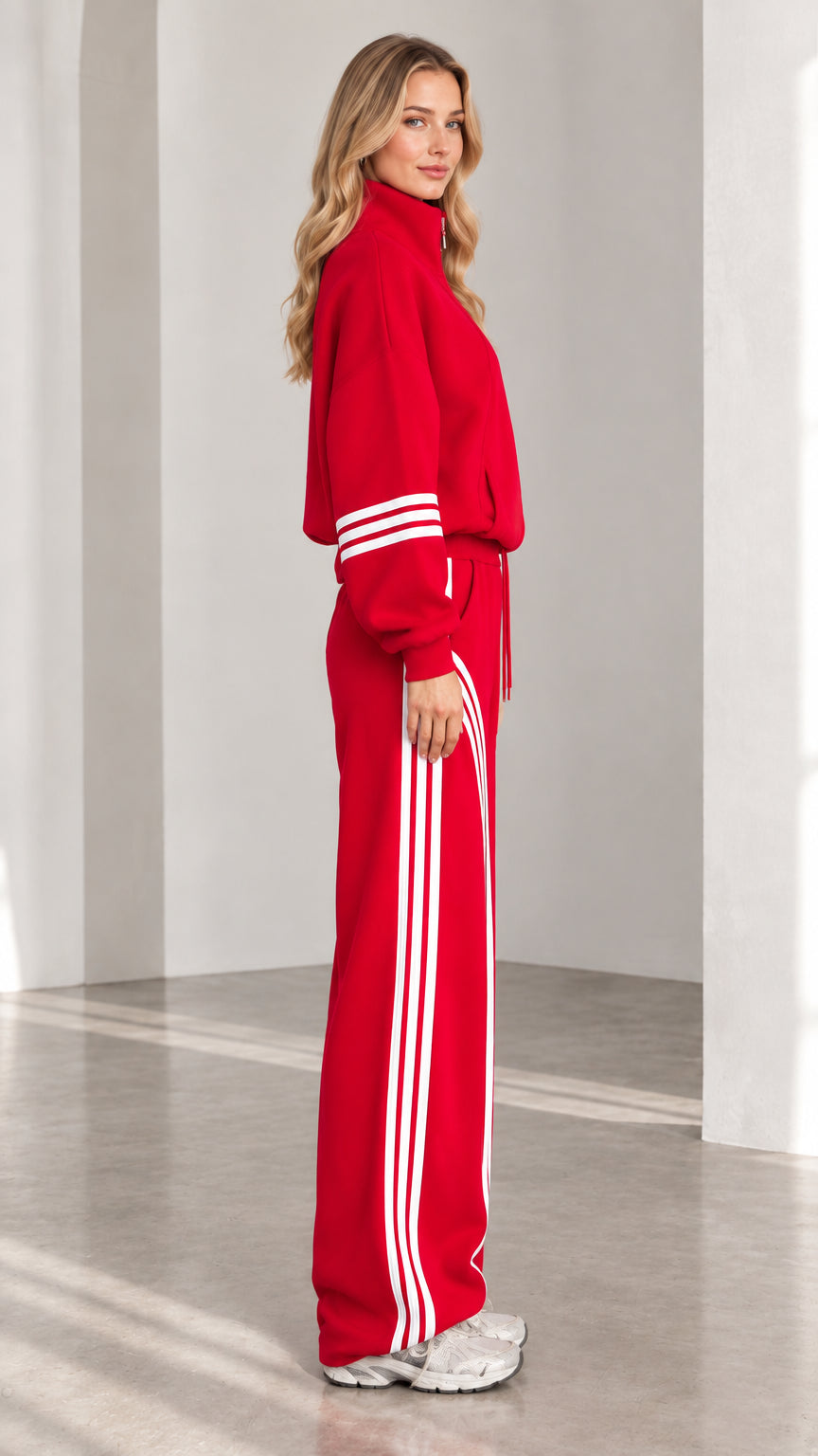 Side profile view of red two-piece tracksuit showing contrast leg stripes