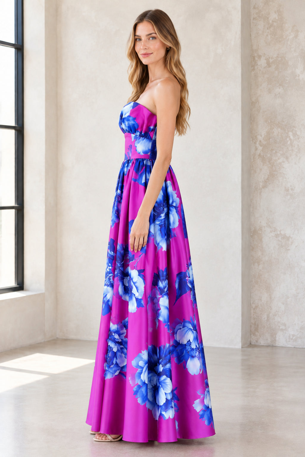 Side angle view of magenta strapless floral A-line maxi gown