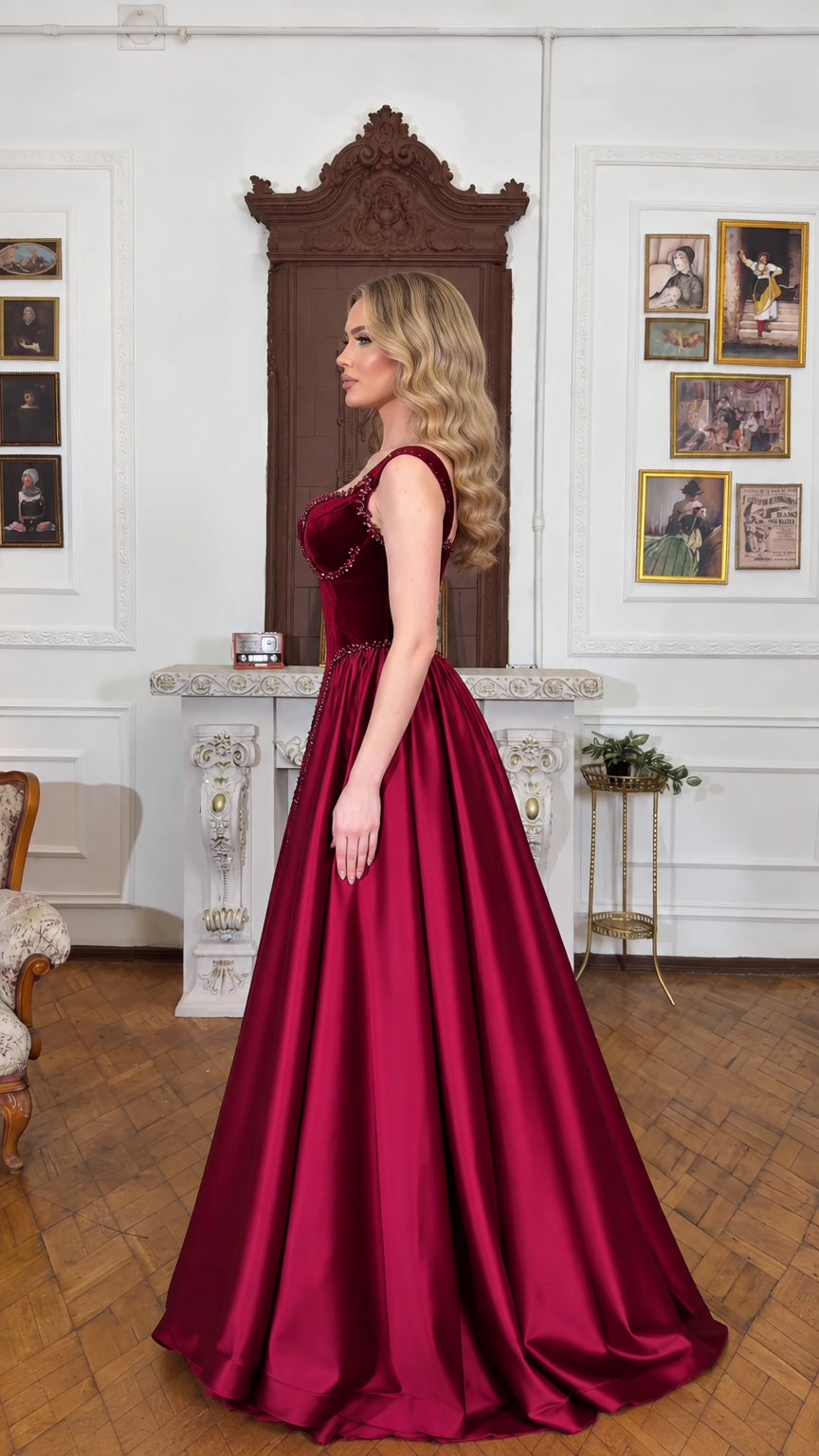Side profile of model in floor-length burgundy formal ball gown