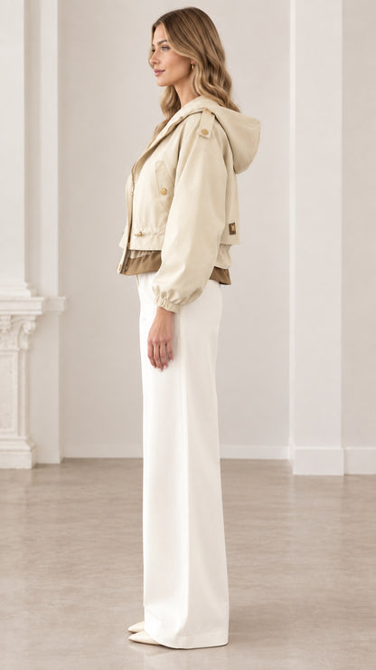 Side profile of woman wearing beige cropped hooded utility jacket