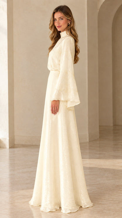 Side profile view of woman modeling ivory high neck flared sleeve formal dress