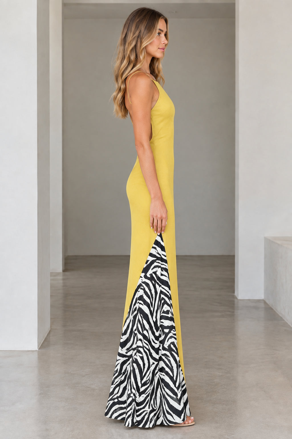 Side profile view of yellow spaghetti strap maxi dress highlighting zebra pattern insert