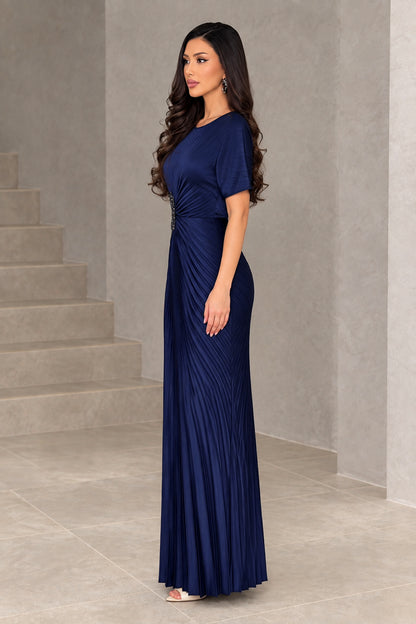 Side profile of navy blue pleated evening gown showing subtle waist gather