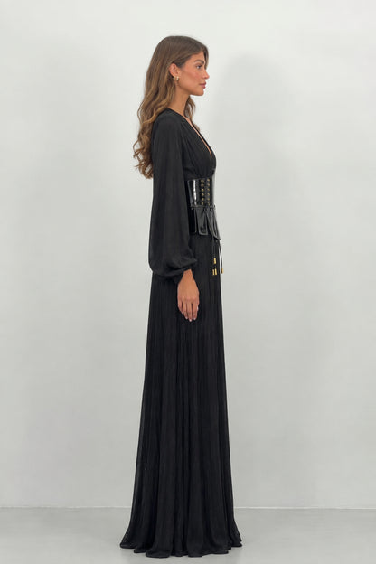 Side profile view of black long sleeve pleated evening gown