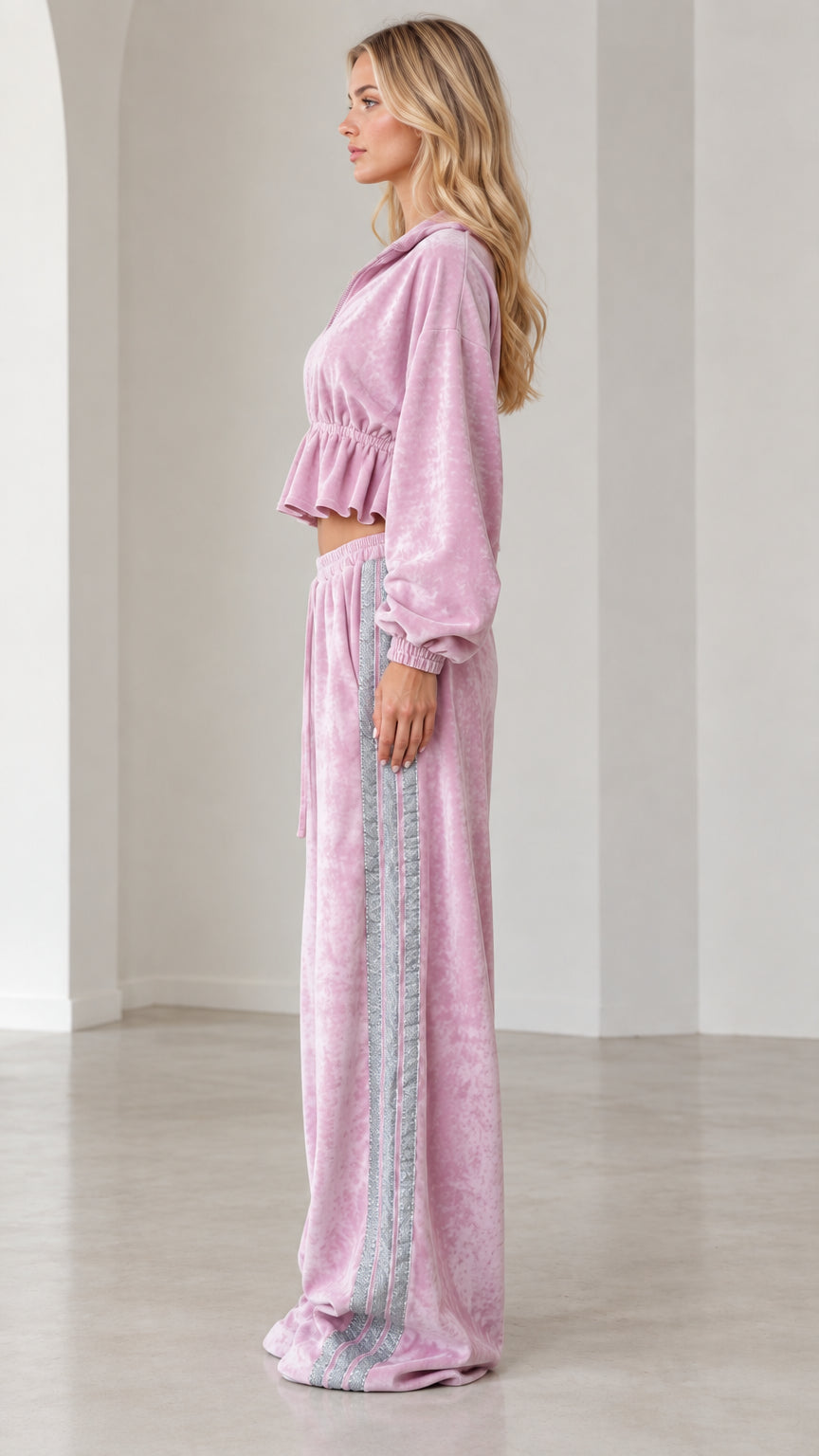 Side profile view of model in lilac pink velour lounge set showing cropped jacket and side stripe pants