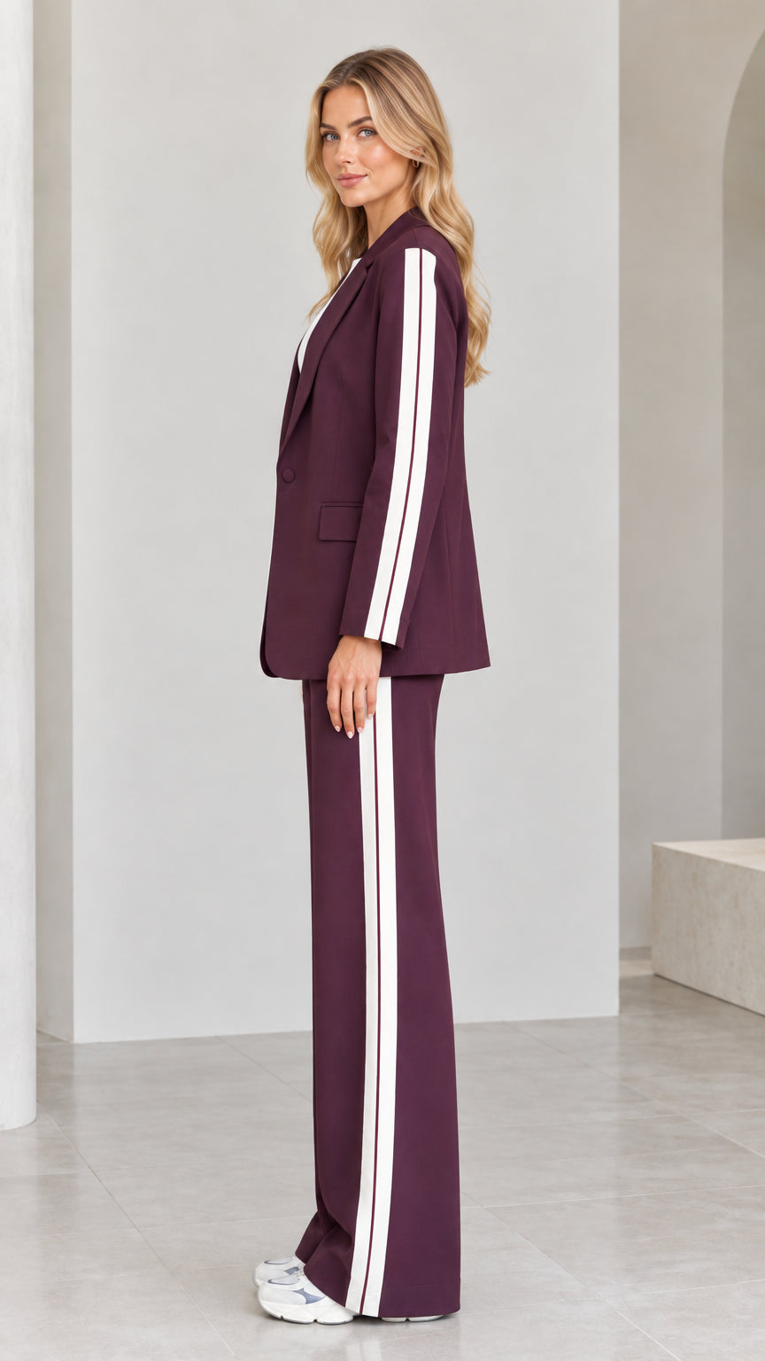 Side view of model in burgundy striped blazer suit set showing sleeve and pant stripe detailing