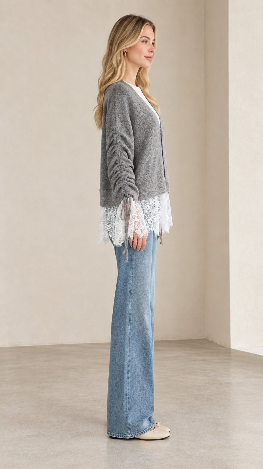 Side profile view of woman modeling heather grey knit cardigan with ruched sleeves and lace hem