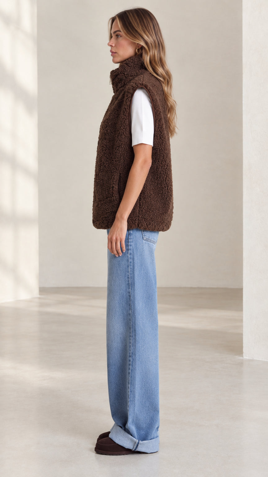 Side profile view of woman wearing brown teddy fleece vest