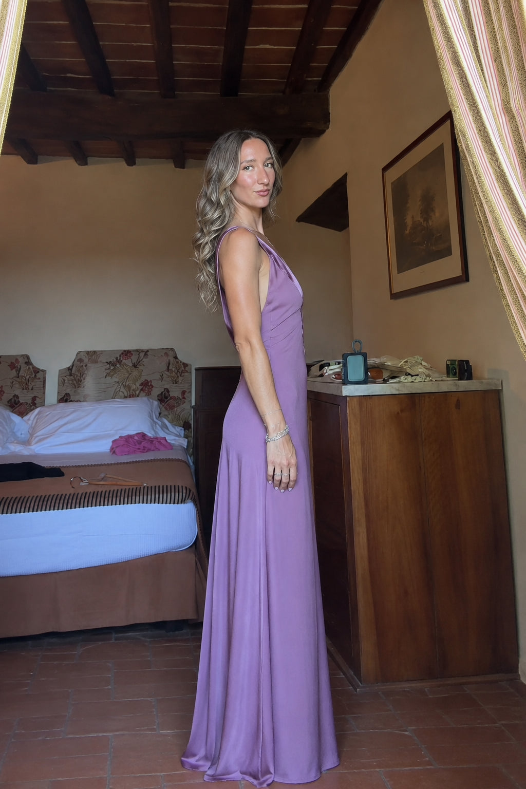 Side profile of model wearing mauve floor-length satin evening gown