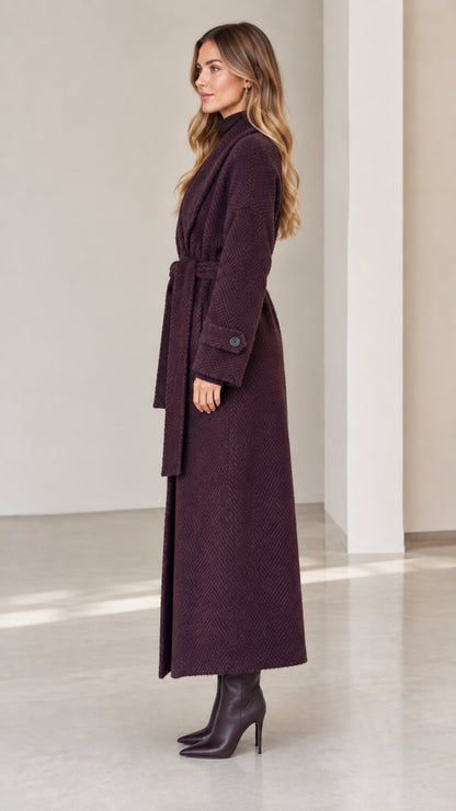 Side profile of woman wearing deep plum full length wrap coat