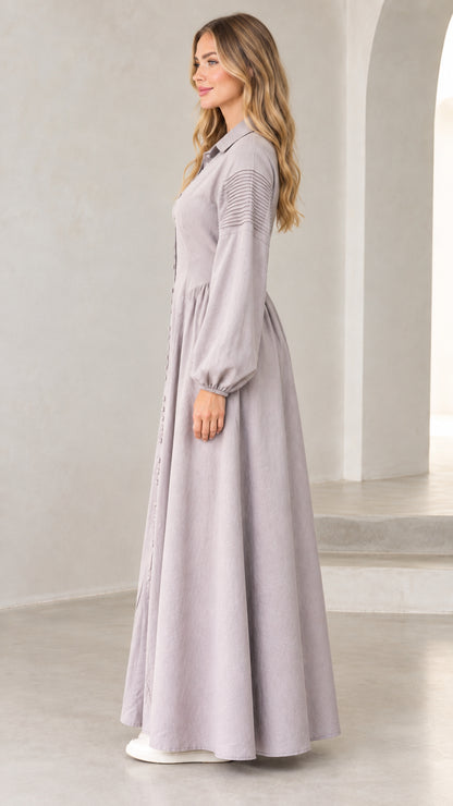 Side profile of woman in lavender grey long sleeve button-down maxi dress