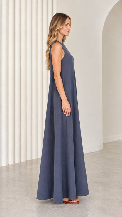 Side profile view of model showcasing the flowing A-line silhouette of the slate blue maxi dress