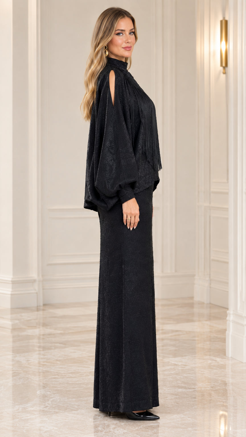 Side profile of model wearing black two-piece maxi set with cold-shoulder sleeves