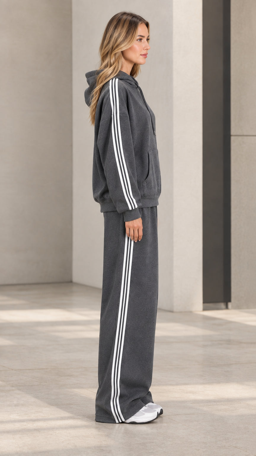 Side profile view of model wearing charcoal grey striped hoodie and sweatpants set