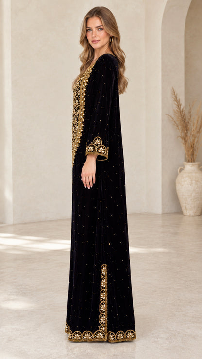 Side view of black velvet maxi dress showing side slit and embroidered border