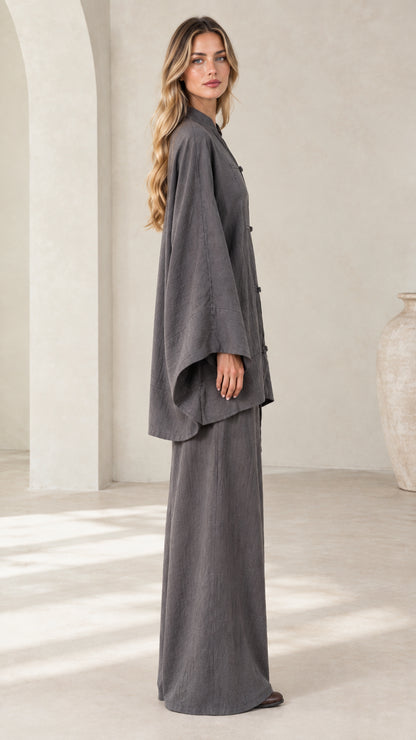 Side profile view of women's charcoal gray draped tunic top and matching palazzo pants