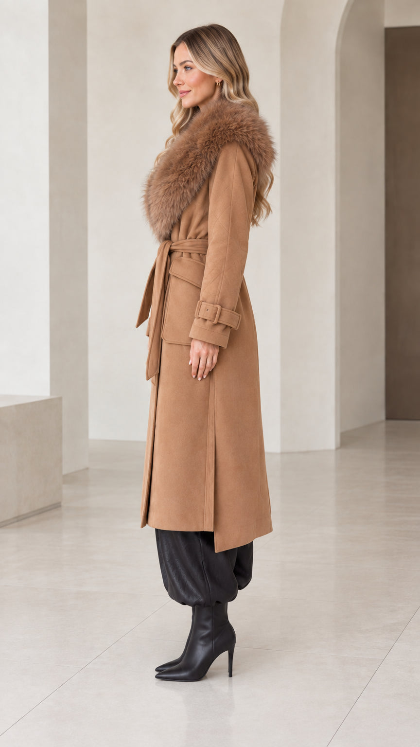 Side angle view of model wearing camel belted longline overcoat with faux fur trim
