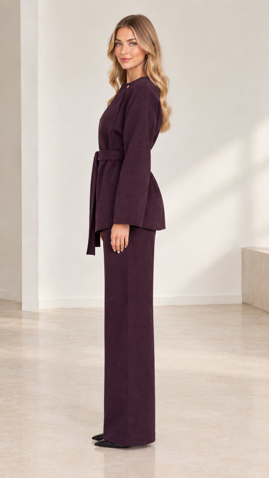 Side profile view of deep plum two-piece belted tunic and tailored wide-leg trousers