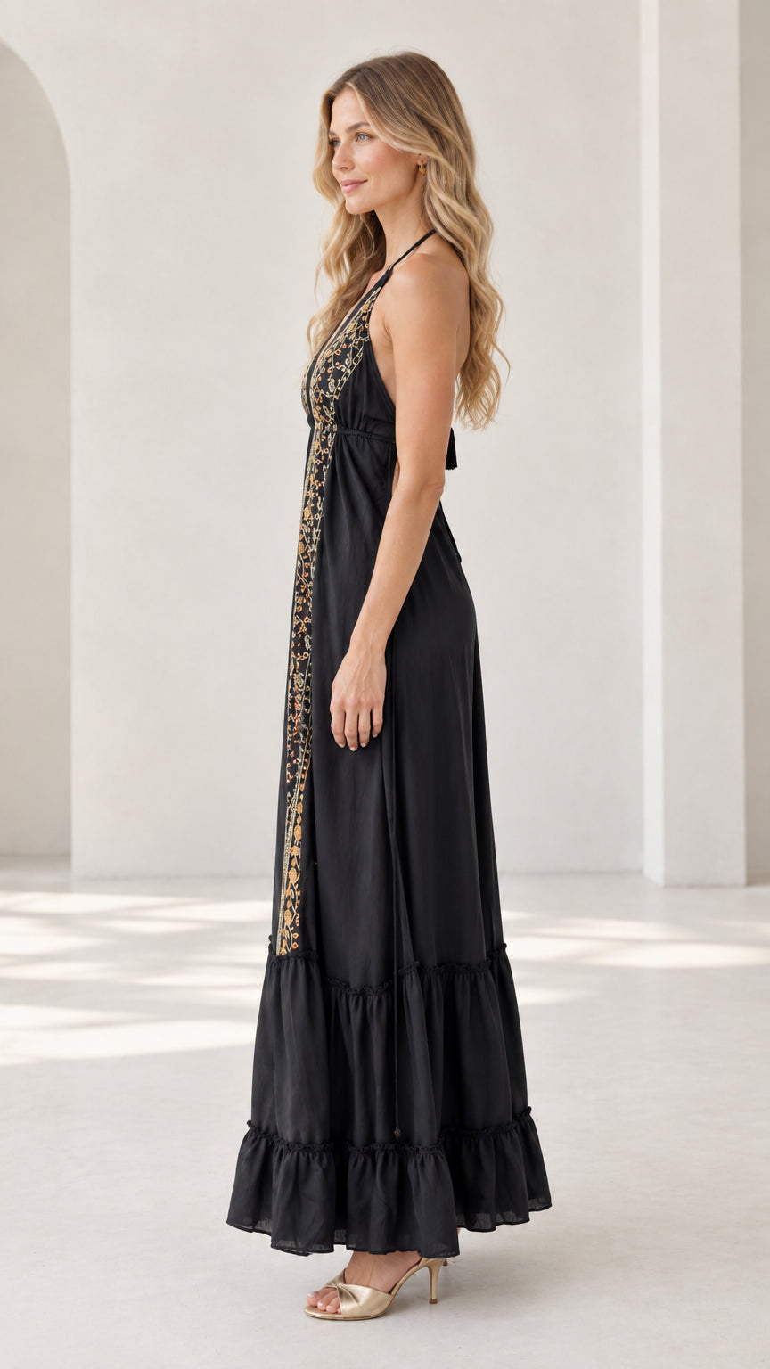 Side profile view of black embroidered halter maxi dress