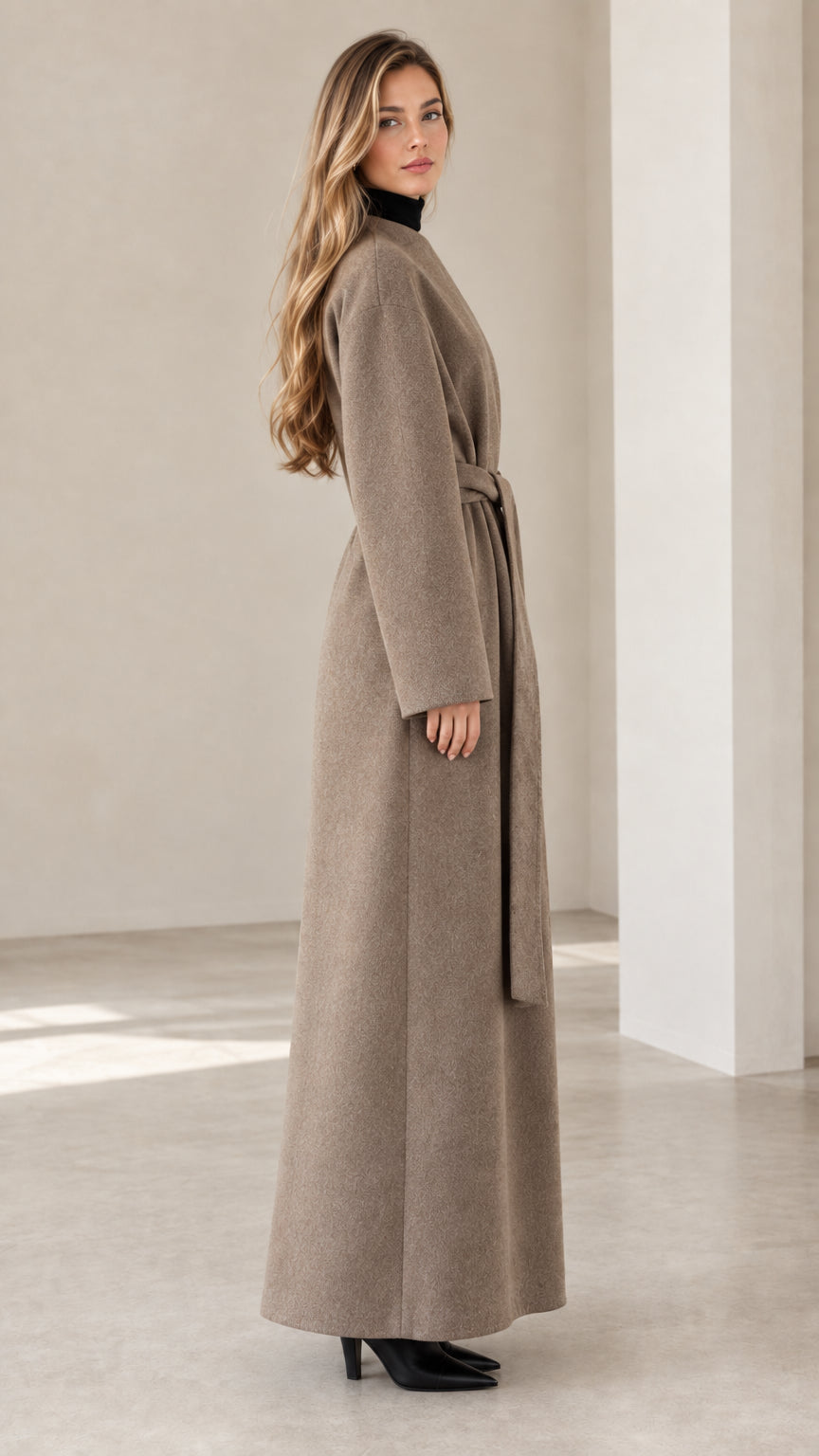 Side profile view of model wearing full-length taupe wrap coat