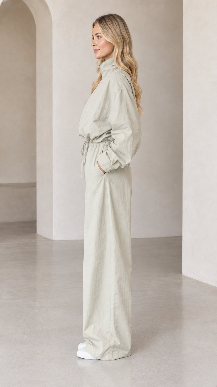 Side profile view of woman wearing Light Sage relaxed-fit utility jumpsuit