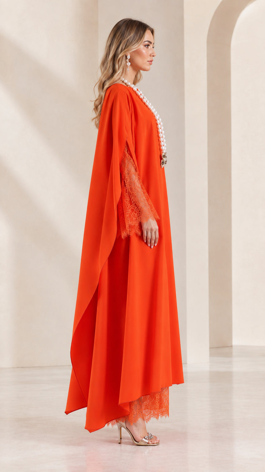 Side profile view of orange cape sleeve maxi gown with flowing silhouette