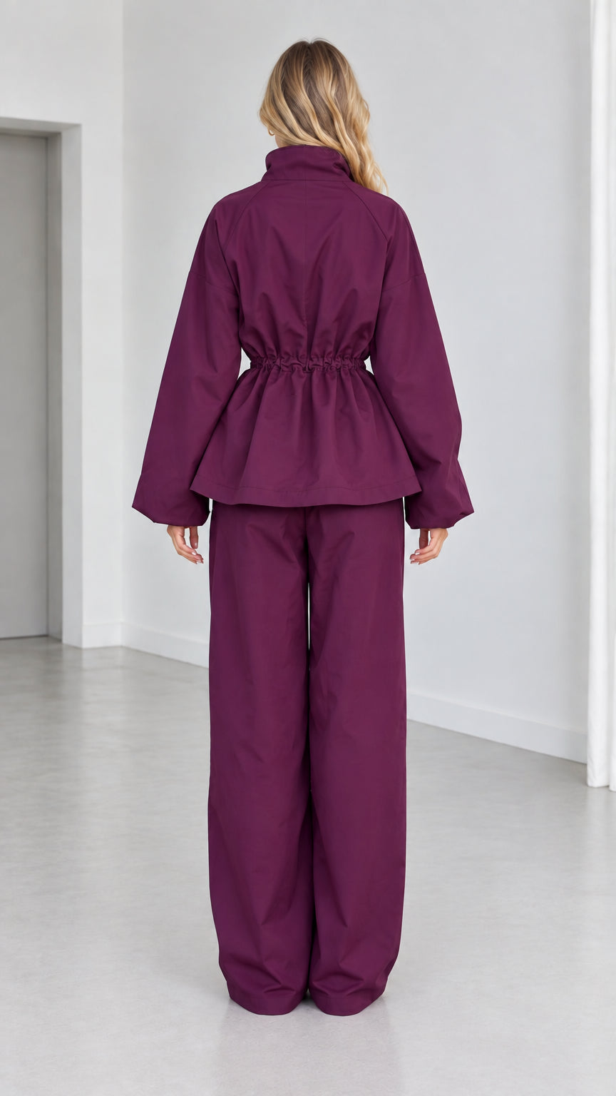 Back view of plum peplum tracksuit set showing gathered waist and wide trousers