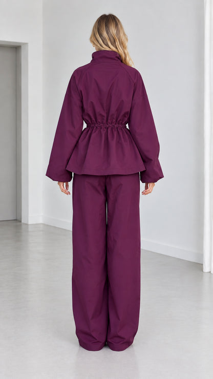 Back view of plum peplum tracksuit set showing gathered waist and wide trousers