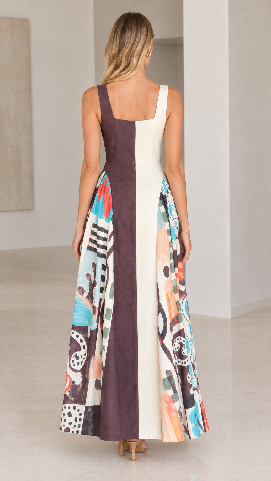 Back view of model wearing chocolate brown and cream two-tone maxi dress with abstract pattern sides