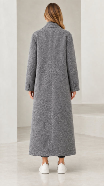 Back view of woman wearing full-length grey bouclé lapel coat