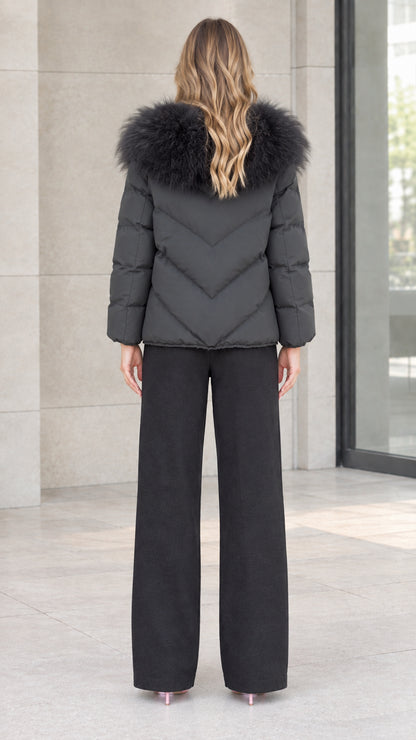 Back view of model showing chevron quilting and fluffy fur collar on black winter coat